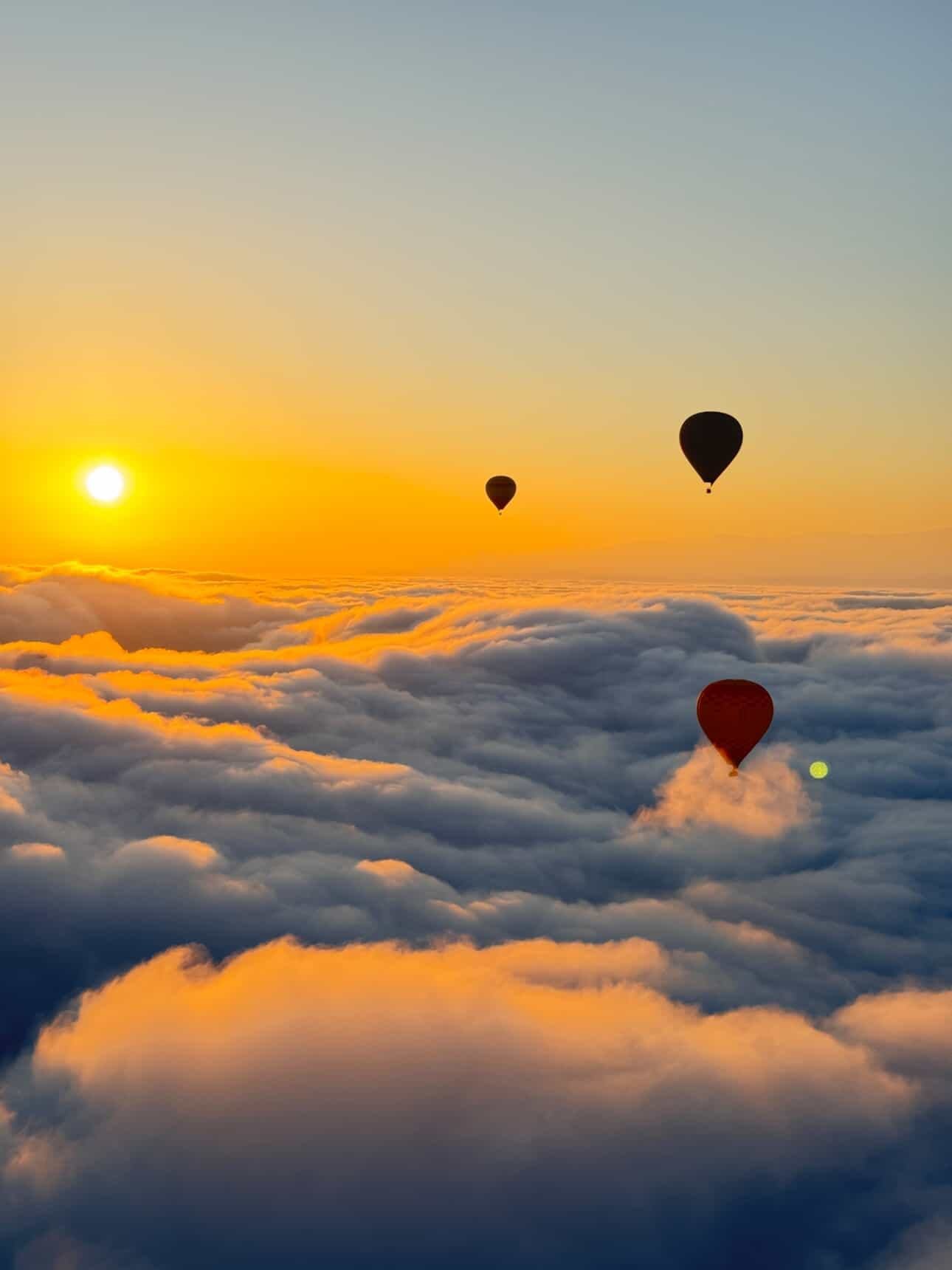 Globos aerostáticos sobre un mar de nubes al amanecer cerca de Marrakech