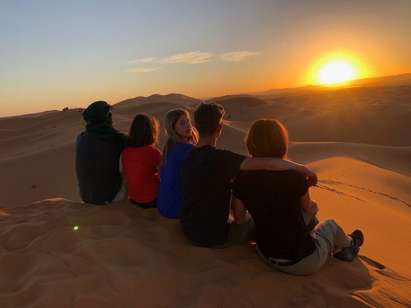 Una familia contemplando el atardecer en las dunas del Sáhara