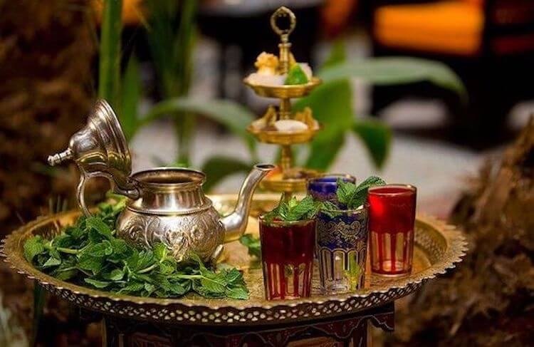 Té a la menta marroquí servido en una bandeja de plata con pastas