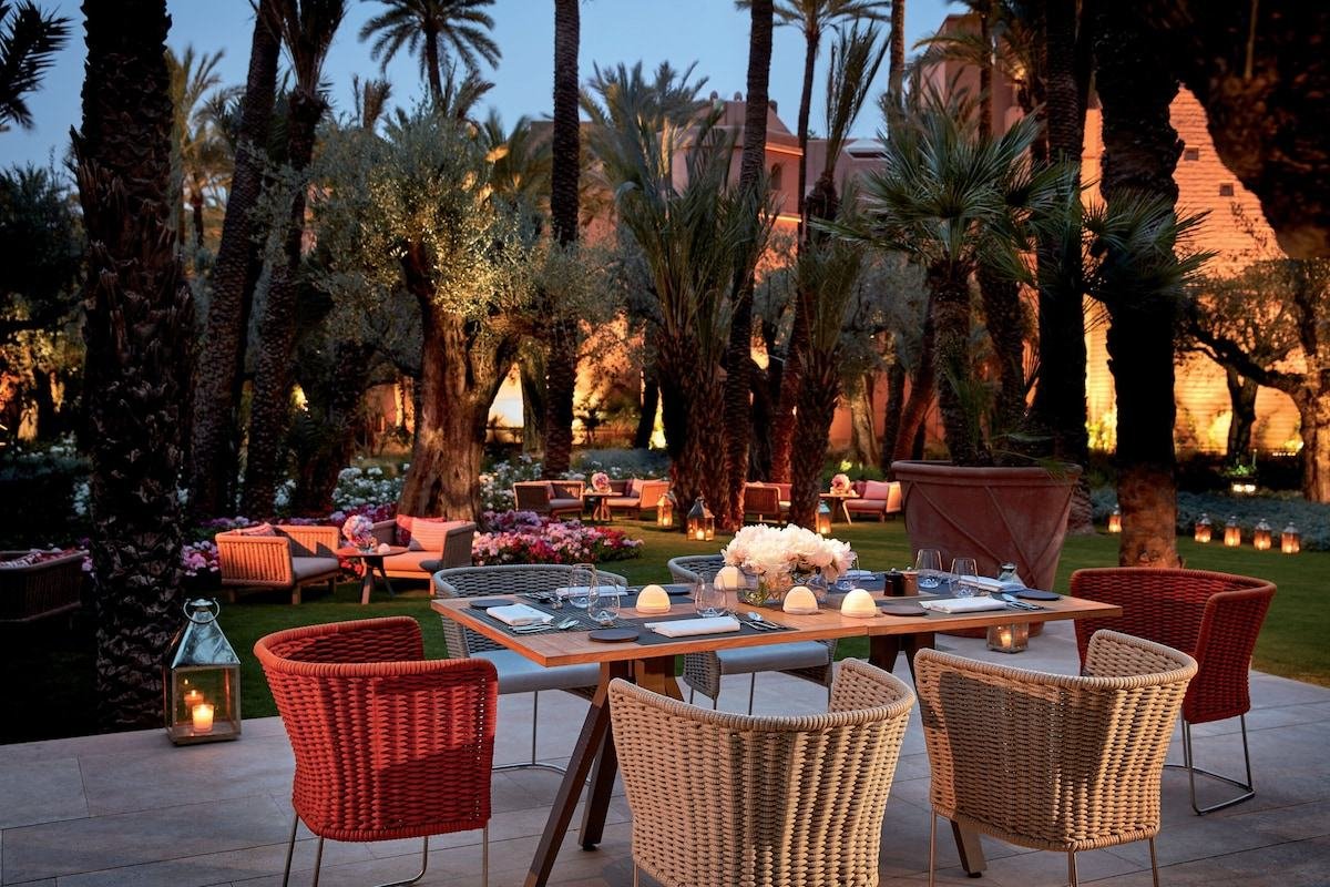 Mesa de cena a la luz de las velas en los jardines de un hotel palacio en Marrakech