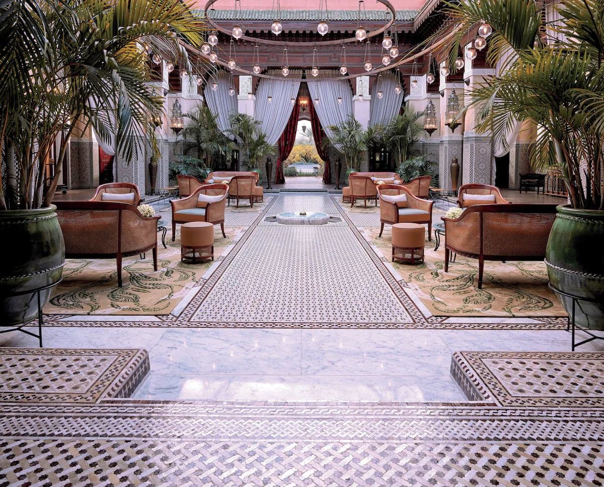 Patio de un riad palacio con suelos de zellige y faroles en Marrakech